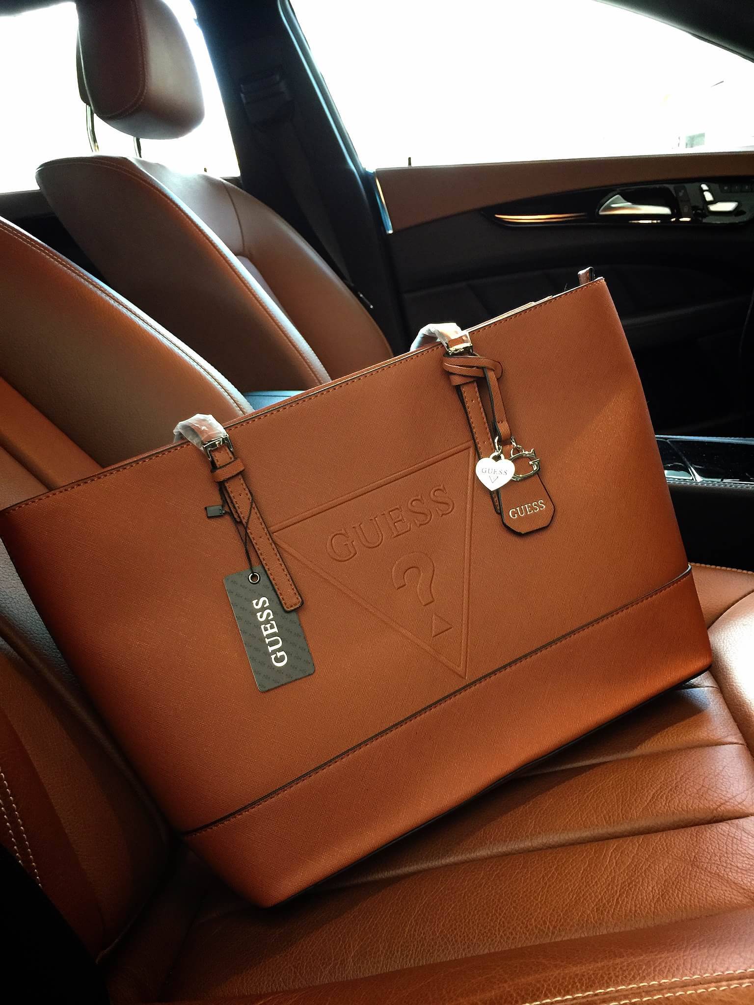 Guess Saffiano Shopping Bag กระเป๋าถือและคล้องบ่าทรงช้อปปิ้งใบใหญ่ หนังSaffiano ใส่เอกสารขนาด A4 ได้ จุของได้เยอะ ด้านหน้าสลักแบรนด์หนังลายนูนพร้อมประดับtagสายหนังถอดออกได้ เปิดปิดด้วยซิปเดียวด้านบน ภายในบุผ้าติดโลโก้ มีช่องเล็กและข่องใส่โทรศัพท์ เรียบง่า