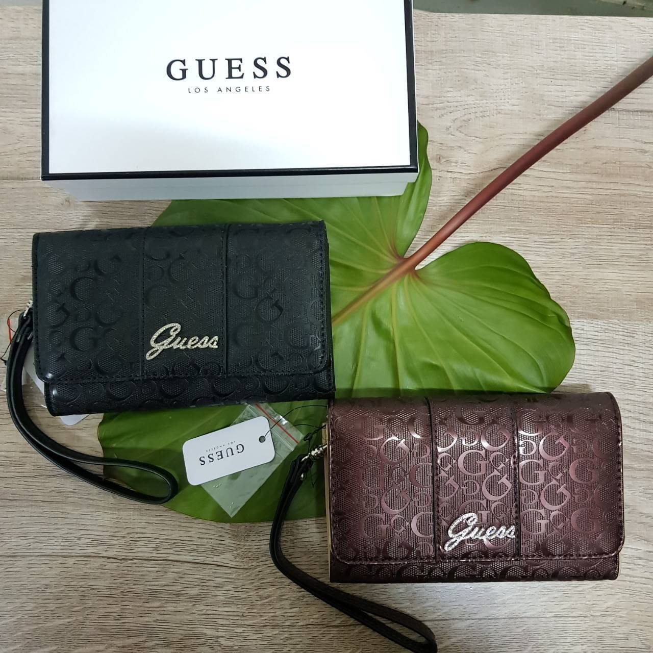 Guess leather wallet กระเป๋าสตางค์ใบกลาง มีสายคล้องมือสามารถถอดได้ ด้านหน้าแต่งโลโก้แบรนด์โลหะสีเงิน ภายในมีช่องใส่ธนบัตร,เหรียญ บัตรต่างๆ ปิดเปิดใช้งานสะดวก