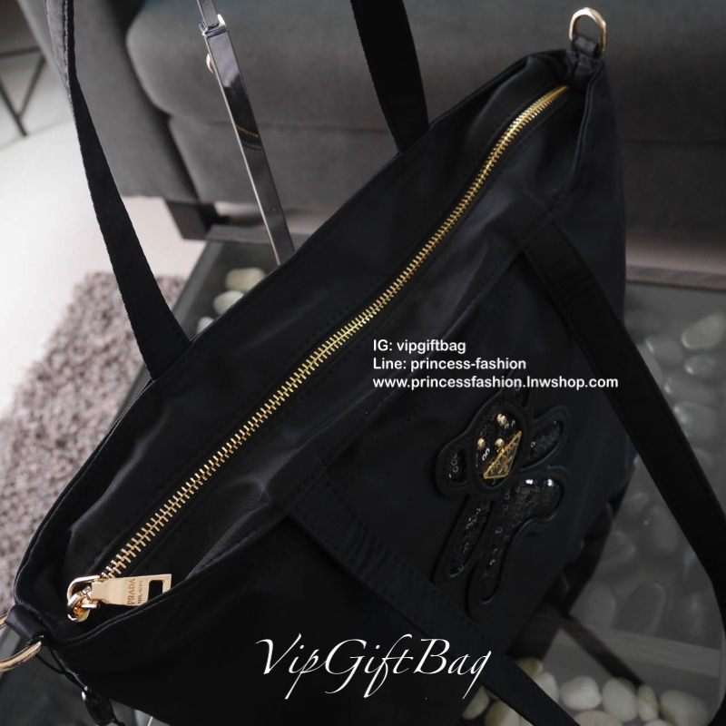 เอาใจคนชอบกระเป๋าไซส์กลาง *มาพร้อมสายยาว สำหรับกระเป๋าอเนกประสงค์ ทรง TOTE จากแบรนด์ PRADA เป็น กระเป๋าผ้าไนล่อน ตามแบบฉบับของแบรนด์เลย ใบนี้มีสายยาวให้ค่ะ เลิศมาก สะพายเป็น shoulder bag หรือ ถือได้คะ ด้านหน้าเป็นลายหมี ปั๊กกลิ้ตเตอร์ + logo brand ใช้แล้ว