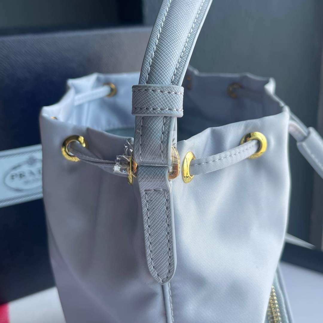 Prada Duet Re-Nylon Bucket shoulder bag / Prada Nylon bucket bag Pastel เกรดใช้สลับใบจริง ออริจินอล ใช้งานต่างประเทศได้ น้องสาวสุดสวยมาให้จับจองอีกหนึ่ง สีพาสเทลน่ารักละมุนมากๆ ค่ะ กระเป๋าสะพายข้าง ทรงขนมจีบ ไซส์มินิ ขนาดน่ารักน่าใช้มาก วัสดุขอบหนังแท้ แล