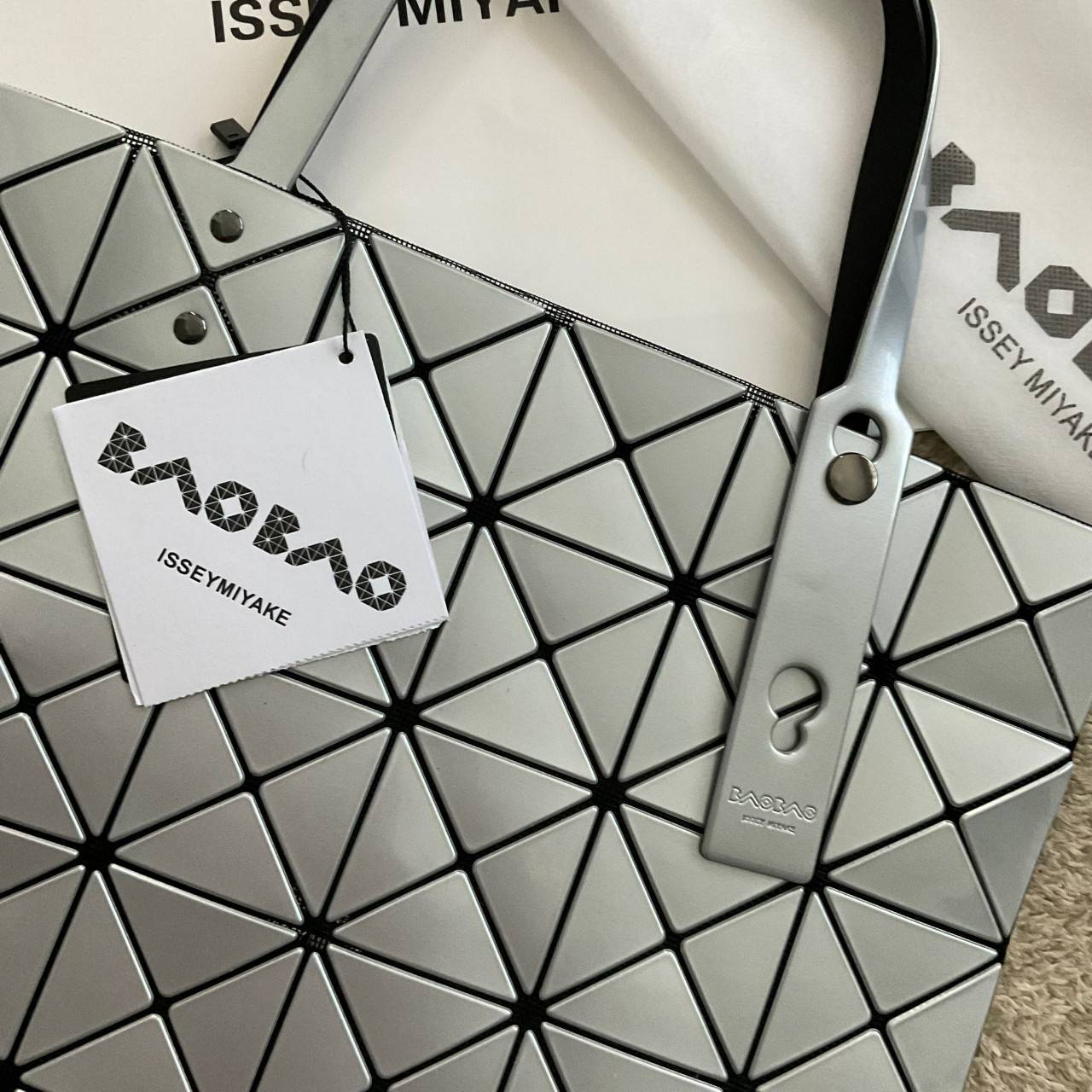 BAO BAO ISSEY MIYAKE TOTE BAG (6x6) กระเป๋าสะพายไหล่ ใบใหญ่ ทรงโท้ท จุดเด่นคือ ปรับได้หลายทรงตามเอกลักษณ์เฉพาะของแบรนด์นี้ ด้านในใส่ของได้เยอะมาก ใส่ไอแพด สมุดโน้ตได้สบายเลย พร้อมช่องซิปใส่ของให้อีกหนึ่งช่อง วัยทำงานหรือวัยนักศึกษา อย่างน้อยต้องมีแบรนด์นี