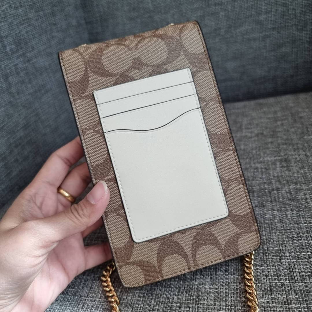 COACH NORTH/SOUTH PHONE CROSSBODY IN SIGNATURE CANVAS F55636 F39955 สุดคลาสสิคกับกระเป๋าสะพายเอนกประสงค์ Case phone ใส่โทรศัพท์มือถือได้ทุกรุ่น ดีไซน์ลายเอกลักษณ์ วัสดุหนังแคนวาสเคลือบลาย ฝาและภายในเป็นหนังสังเคราะห์เรียบ เปิด-ปิดด้วยกระดุม สายสะพายยาวประ