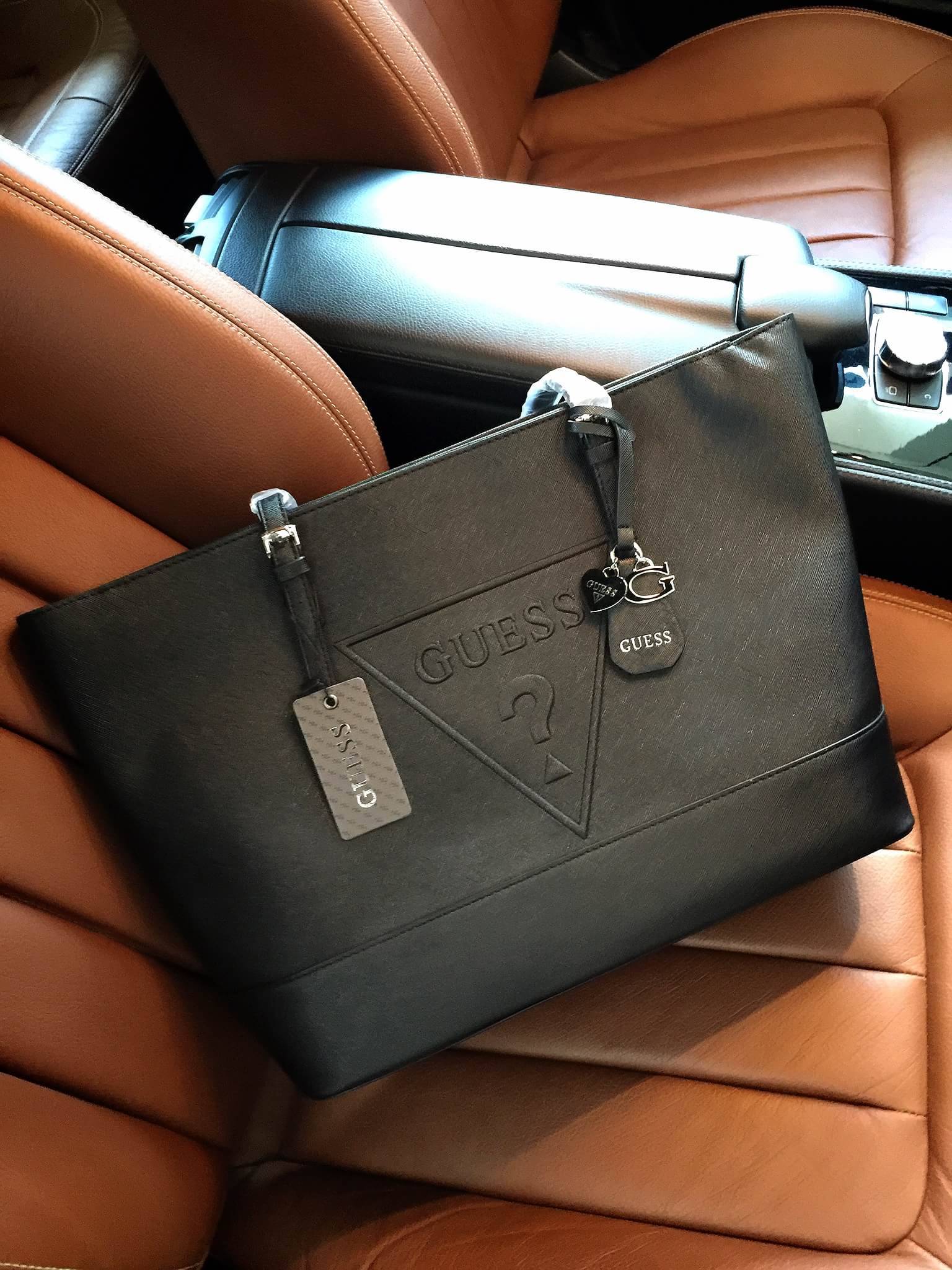 Guess Saffiano Shopping Bag กระเป๋าถือและคล้องบ่าทรงช้อปปิ้งใบใหญ่ หนังSaffiano ใส่เอกสารขนาด A4 ได้ จุของได้เยอะ ด้านหน้าสลักแบรนด์หนังลายนูนพร้อมประดับtagสายหนังถอดออกได้ เปิดปิดด้วยซิปเดียวด้านบน ภายในบุผ้าติดโลโก้ มีช่องเล็กและข่องใส่โทรศัพท์ เรียบง่า