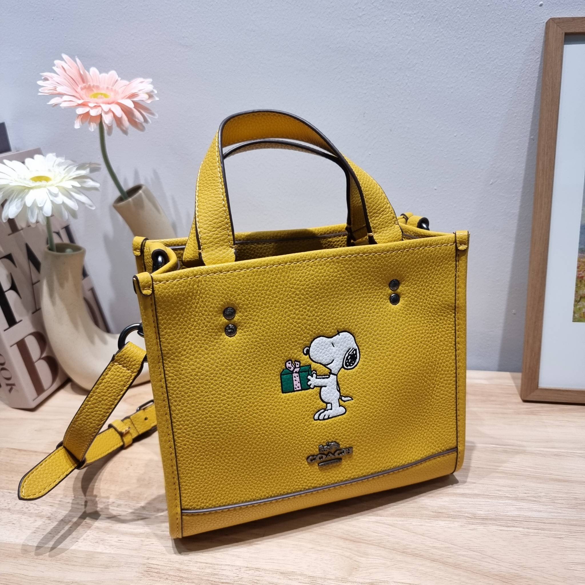 coach x peanuts dempsey tote 22 with snoopy present motif CE918 คอลเลคชั่นใหม่ น้องน่ารักเกินต้านไปมาก!! กับกระเป๋าทรงโท้ท ไซส์กำลังสวย ดีไซน์ ลายการ์ตูนยอดฮิต ที่ใครๆก็ต้องรู้จัก พิมพ์คมชัดลงบนหนัง pepble ผิวสัมน่าใช้ ปากกระเป๋ามีกระดุมแม่เหล็กปิดกันของห