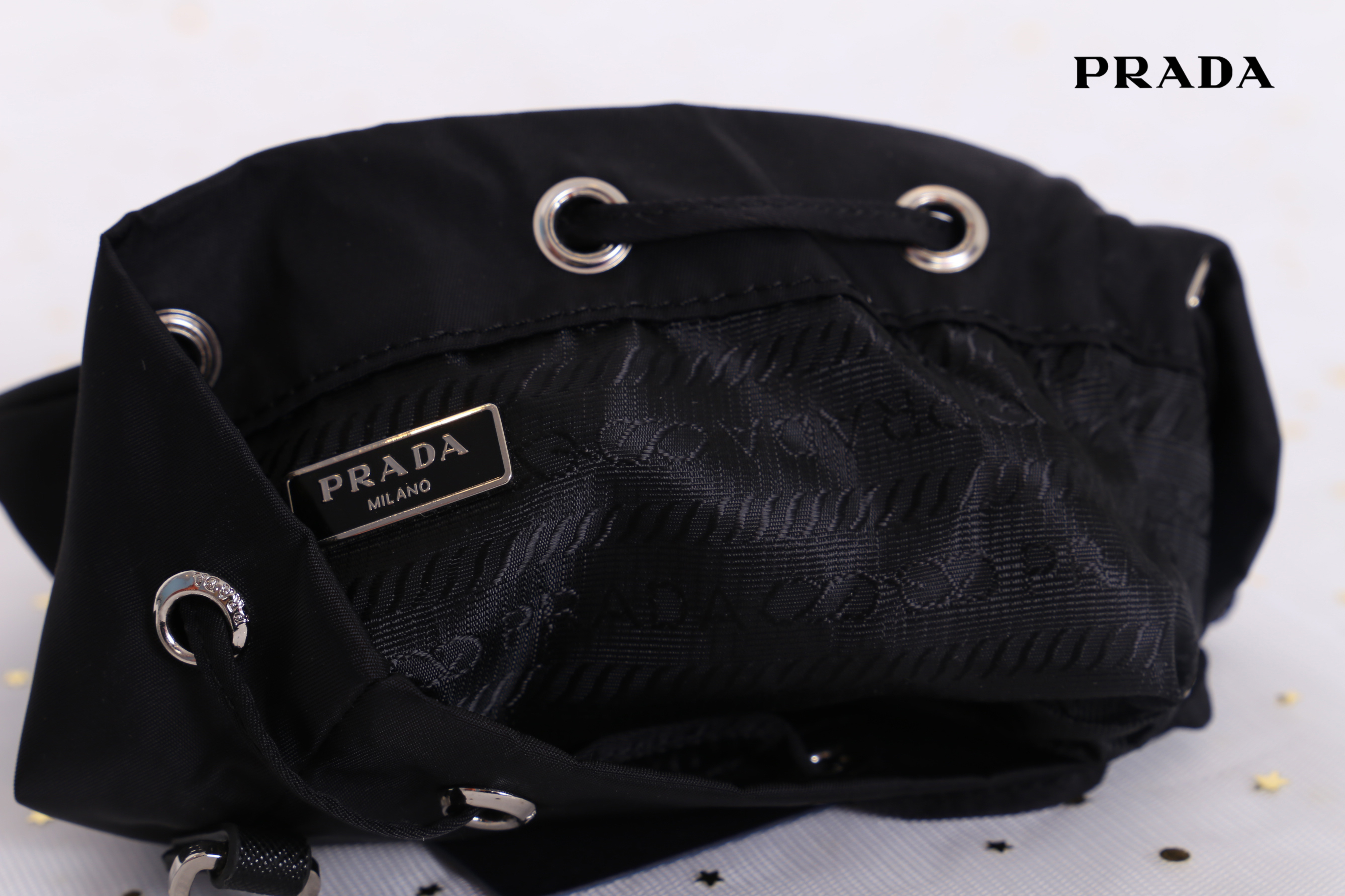 Prada mini nylon drawstring handbag / PRADA Bucket Bag ทรงสวยน่ารัก วัสดุผ้า Nylon คุณภาพดี อะไหล่เงินสวยสุดคลาสิค เปิดปิดแบบหูรูด ด้านในโล่งกว้างจุของได้พอประมาณเลยค่ะ ใส่ Iphone+ หรือรุ่นเทียบเท่าได้แบบสบายๆ ซับในพิมพ์ลายแบรนด์ ตามแบบฉบับแบรนด์