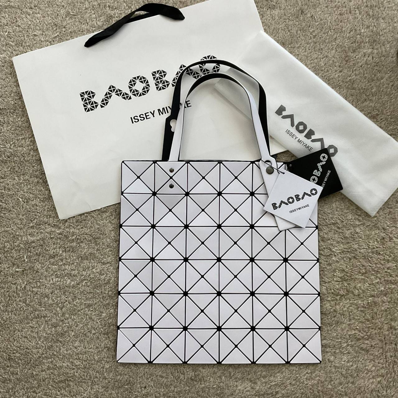 BAO BAO ISSEY MIYAKE TOTE BAG (6x6) กระเป๋าสะพายไหล่ ใบใหญ่ ทรงโท้ท จุดเด่นคือ ปรับได้หลายทรงตามเอกลักษณ์เฉพาะของแบรนด์นี้ ด้านในใส่ของได้เยอะมาก ใส่ไอแพด สมุดโน้ตได้สบายเลย พร้อมช่องซิปใส่ของให้อีกหนึ่งช่อง วัยทำงานหรือวัยนักศึกษา อย่างน้อยต้องมีแบรนด์นี