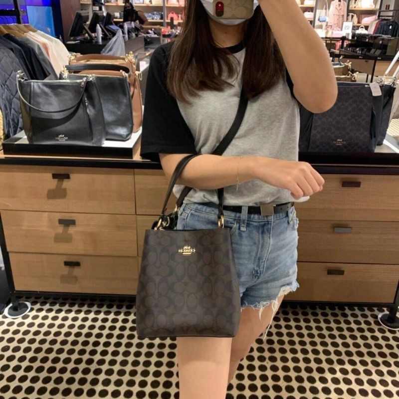 COACH 2312 SMALL TOWN BUCKET BAG IN SIGNATURE CANVAS รุ่นยอดนิยมใบเล็กมาครบสีแล้วจ้า กระเป๋าทรงบัคเก็ต สีผู้ดี๊ผู้ดี ตัวกระเป๋าดีไซน์คลาสสิคลายซี ดูโดดเด่น วัสดุหนังแคนวาสเคลือบลาย สวยคมทุกมุมจริงๆ!! เปิด-ปิดด้วยกระดุมแม่เหล็กทั้ง 2 ฝั่ง ภายในเป็นช่องโล่ง