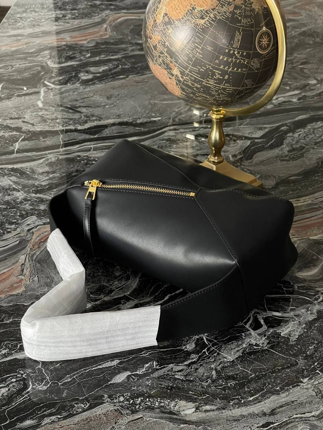 Loewe Puzzle Hobo bag กระเป๋ารุ่น Puzzle มีความพิเศษในหลายด้าน ไม่ว่าจะเป็นรูปทรงที่แปลกใหม่ มินิมอลด้วยโลโก้อนาแกรมแบบประทับ ดูหรู เป็นกระเป๋า Unisex ที่ไม่ว่าคุณจะเป็นผู้หญิงหรือผู้ชายก็ใช้งานได้ ลายกระเป๋าได้มาจากการนำหนังมาเย็บต่อกันทั้งหมด ถึงแม้ว่าข