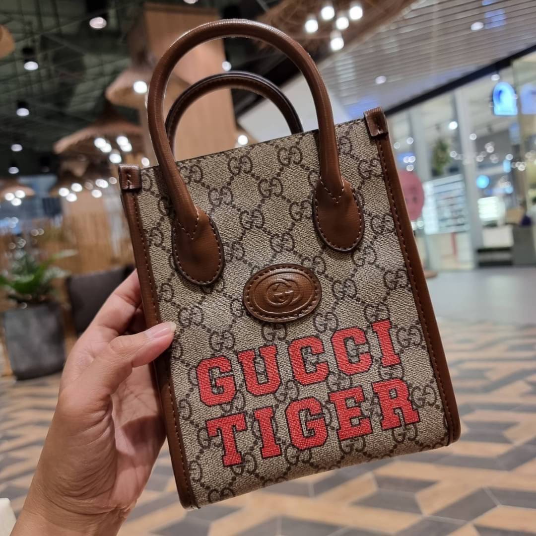 GUCCI Tiger GG mini tote bag ไซส์มินิ ร้อนแรงไฟลุก!! ต้อนรับปีเสืออย่างเป็นทางการ จัดให้แบบเลิศๆ กับกระเป๋าทรงโท้ท วีไอพีพรีเมี่ยมกิ๊ฟ ไซส์มินิ โดดเด่นด้วยฟอนท์ตัวใหญ่ สวยเอกลักษณ์ วัสดุหนังแคนวาสตัดขอบด้วยหนังแท้ ภายในเป็นช่องโล่ง ใส่ของจุกจิกได้ ใส่โทรศ
