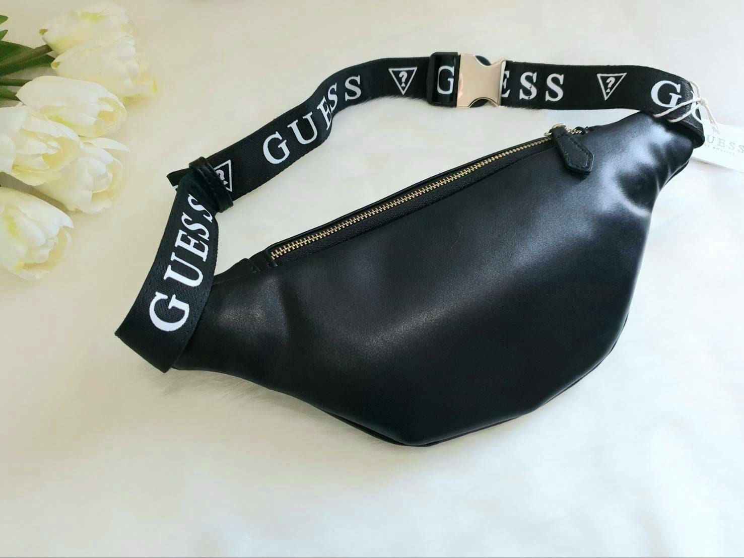 GUESS GESABEL GYM FANNY PACK กระเป๋าหนังคาดเอว/อก ด้านหน้าปั๊มโลโก้แบรนด์ทรงสามเหลี่ยม ตัวกระเป๋าเปิดปิดด้วยซิปใช้งานง่าย มี 2 ช่องซิป มีลูกเล่นซ่อนซิปหน้าคาดปิดด้วยสายพิมพ์โลโก้ ภายในกระเป๋าโล่งกว้าง สามารถใส่มือถือได้ทุกรุ่น จุของได้เยอะ รับรองถูกใจสาวๆ
