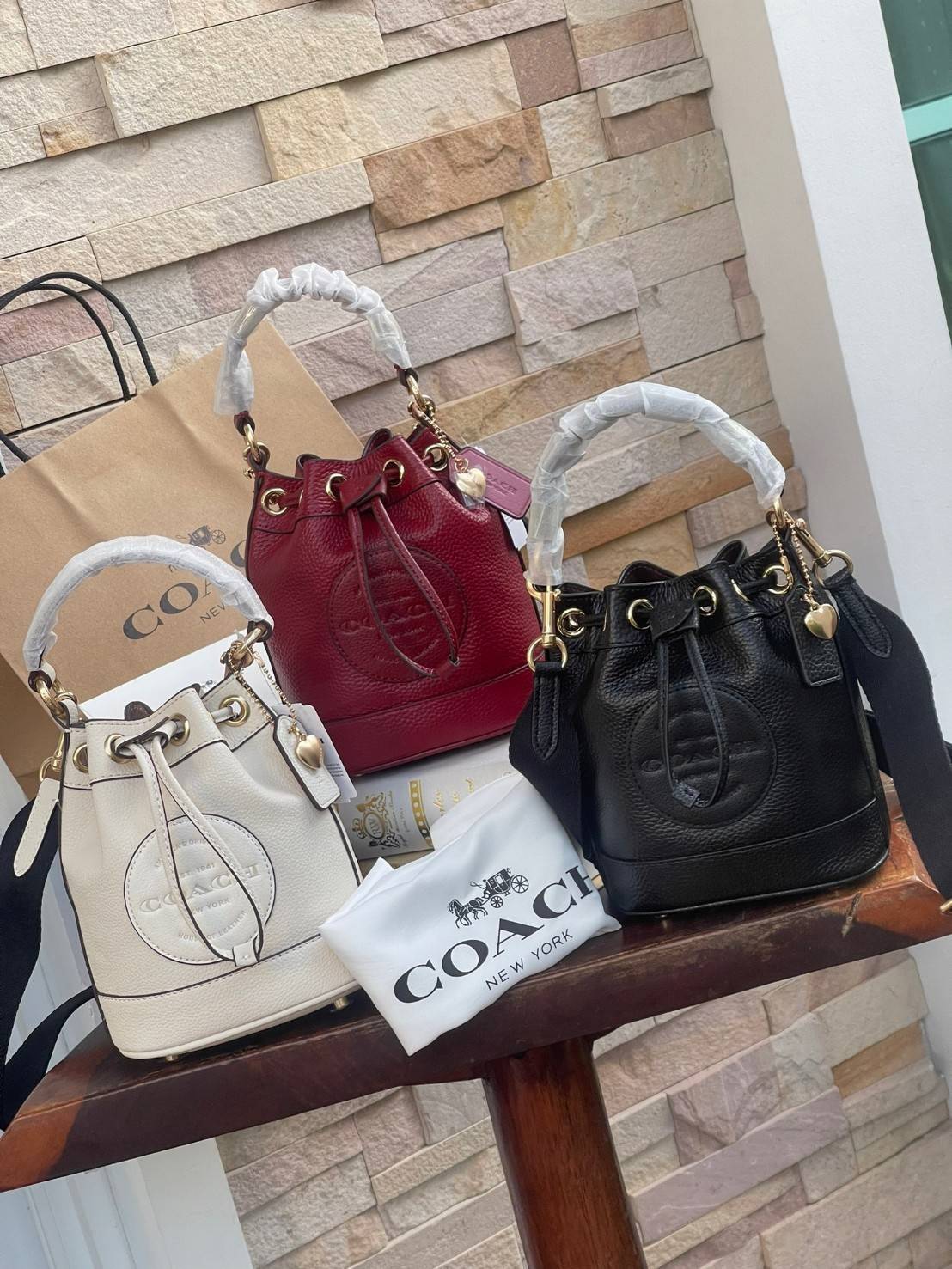 COACH DEMPSEY BUCKET BAG 15 WITH COACH PATCH AND HEART CHARM สวยงามด้วยดีไซน์ทรงตะกร้าแบบมินิมอลแสนน่ารัก ดีเทลสะดุดตา รูปทรงจดจำง่าย ถือแบบชิคๆ หรือยิ่งไปกว่านั้น สายสะพายของกระเป๋าก็สามารถถอดออกเพื่อเปลี่ยนรูปแบบการสะพายได้ทั้งแบบสะพายไหล่และสะพายคาดลำต