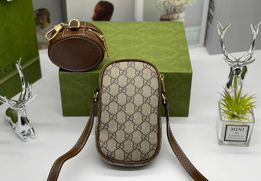 GUCCI Mini bag with Interlocking G / Gucci phone bag เกรดออริจินอล กระเป๋ามินิรังสรรค์จากผ้าแคนวาส Supreme ลายโมโนแกรมของแบรนด์สีเบจและสีน้ำตาลอีโบนี สัญลักษณ์ GG สไตล์นี้มอบความรู้สึกร่วมสมัยพร้อมกระเป๋าใส่ Apple AirPods ที่สามารถถอดออกได้