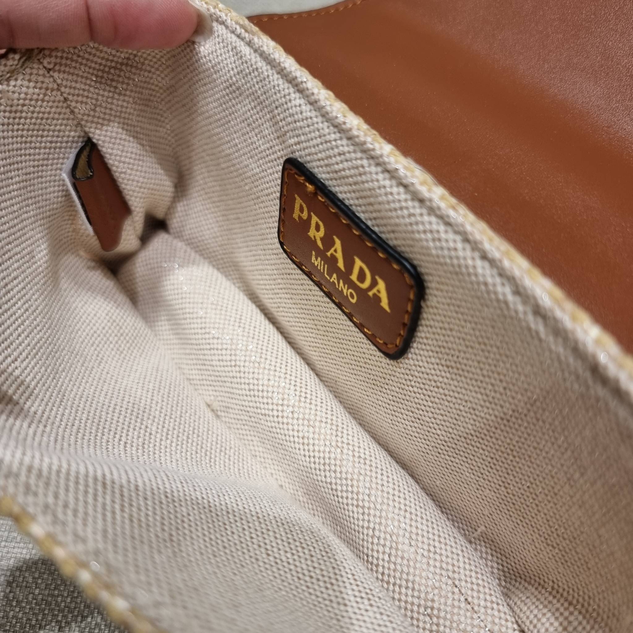 VIP 🥂 PRADA RAFFIA AND LEATHER SHOULDER BAG ลายสานกำลังฮิต! ปังไม่ไหว! ด้วยดีไซน์ล้ำทันสมัย ตกแต่งหนังแท้ผสานกับวัสดุจากธรรมชาติ ออกมาเป็นลายสานที่สวยหรู กับกระเป๋าสะพาย ไซส์กำลังน่ารัก ใส่โทรศัพท์ได้ พกพาง่าย เปิด-ปิดด้วยกระดุมแม่เหล็ก ภายในเป็นช