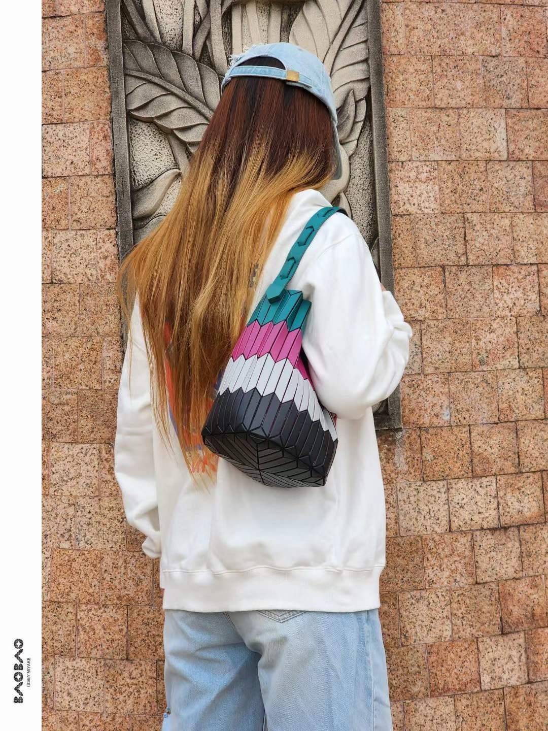 Large : Baobao Issey Miyake Large Bucket กระเป๋าบัคเก็ตขนาดใหญ่สามารถใช้ใส่ร่มพับได้หรือขวดน้ำขนาดเล็กได้ ซีรีย์ใหม่นี้มีจุดเด่นที่แผ่นรูปทรงสี่เหลี่ยมด้านขนานในแนวตั้ง เกิดเป็นรูปทรงสามมิติซึ่งแตกต่างไปจากรูปทรงที่เกิดขึ้นจากแผ่นสามเหลี่ยม หูหิ้วสามารถขย