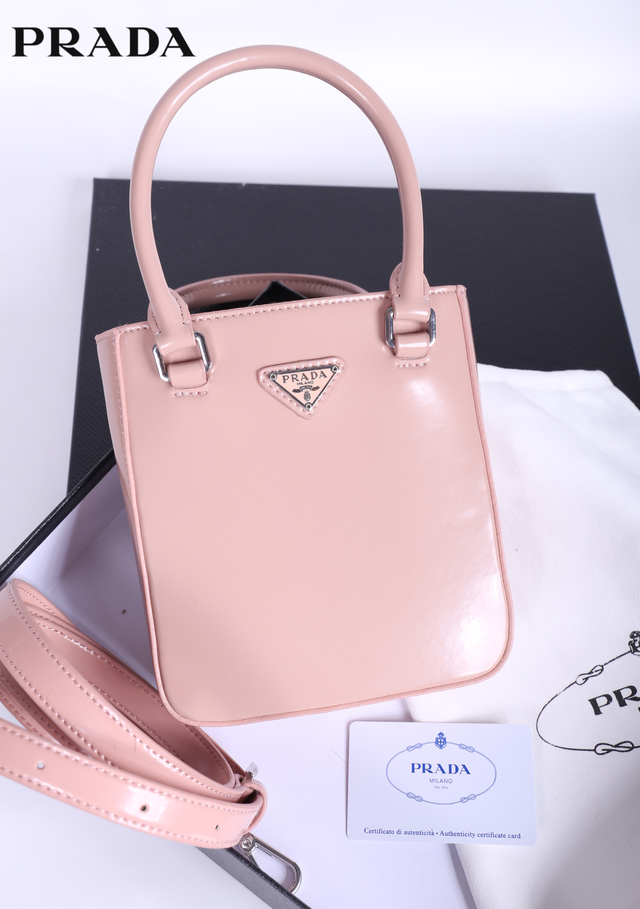 PRADA Small brushed leather tote กระเป๋าTote ขนาดเล็กที่มีดีไซน์ทรงเหลี่ยมโฉบเฉี่ยว วัสดุจากหนังเงาซึ่งเป็นวัสดุที่โดดเด่นของแบรนด์มาตั้งแต่ยุค 90'