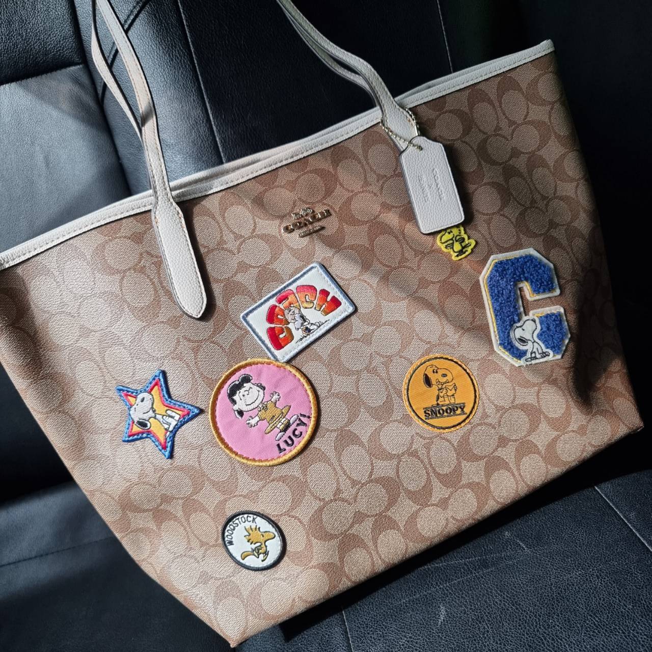 COACH C4292 COACHxPEANUTS CITY TOTE IN SIGNATURE CANVAS WITH VARSITY PATCHES กระเป๋าทรงโท้ทใบใหญ่ กับคอลเลคชั่นคอลแลบใหม่ล่าสุด น่ารักด้วยเหล่าผองเพื่อนสนู้ปพี สวยโดดเด่นมากๆ ใบนี้ใส่ของได้ของครบครัน จุได้แบบไม่ต้องกลัวเต็ม!! วัสดุหนังแคนวาสคุณภาพดี ปากกร