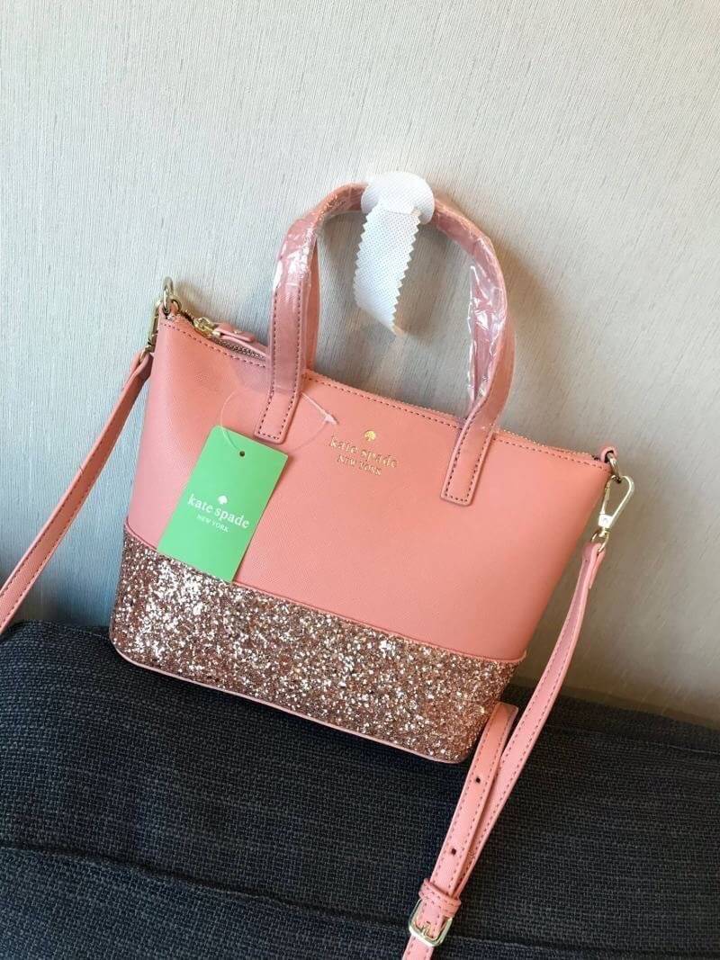 Kate Spade INA Greta Court Glitter Crossbody กระเป๋าถือหรือสะพายใบเล็ก วัสดุหนัง Saffiano สวยหรู ด้านหน้าประดับโลโก้สีทองสวย ก้นกระเป๋ามีดีเทลด้วยGlitter วิ้งๆดูหรู ภายในมีช่องซิปและช่องเล็ก สามารถใส่ ipad mini กระเป๋าสตางค์ใบยาวและของจุกจิกได้เยอะ มีหมุด