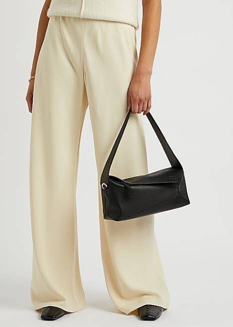 Loewe Puzzle Hobo bag กระเป๋ารุ่น Puzzle มีความพิเศษในหลายด้าน ไม่ว่าจะเป็นรูปทรงที่แปลกใหม่ มินิมอลด้วยโลโก้อนาแกรมแบบประทับ ดูหรู เป็นกระเป๋า Unisex ที่ไม่ว่าคุณจะเป็นผู้หญิงหรือผู้ชายก็ใช้งานได้ ลายกระเป๋าได้มาจากการนำหนังมาเย็บต่อกันทั้งหมด ถึงแม้ว่าข