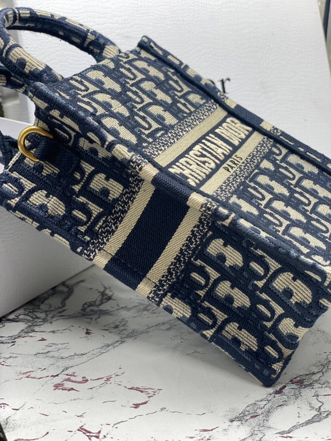 ORI 】Mini Dior Book Tote Phone Bag Blue Dior Oblique Embroidery พร้อมส่งที่ไทย ภาพสินค้าถ่ายจากงานขายจริง ใช้งานต่างประเทศได้ กระเป๋าใบมินิจะใส่โทรศัพท์ได้เช่นเดียวกับของใช้จำเป็นเล็กๆ น้อยๆ ในแต่ละวัน มาพร้อมสายสะพายไหล่แบบปักที่ปรับได้และถอดออกได้ อุปกร