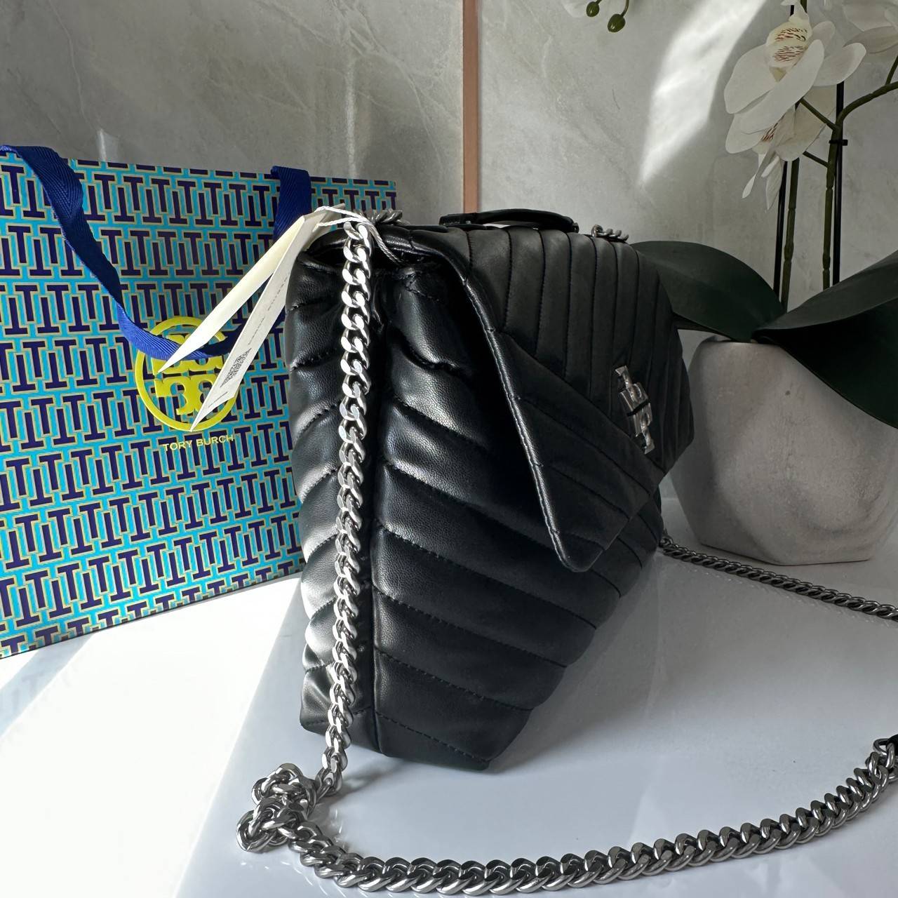 TORY BURCH KIRA CHEVRON CONVERTIBLE SHOULDER BAG กระเป๋าสะพายไซส์ใหญ่ หรูหราสุดคลาสสิก วัสดุหนังแกะทั้งใบ เปิด-ปิดด้วยกระดุมแม่เหล็ก ภายในเป็นช่องโล่ง ใส่ของสำคัญได้ครบ สายสะพายในตัวปรับได้ 2 แบบ สะพายไหล่โซ่คู่หรือจะ ครอสบอดี้ก็เริ่ดคะ
