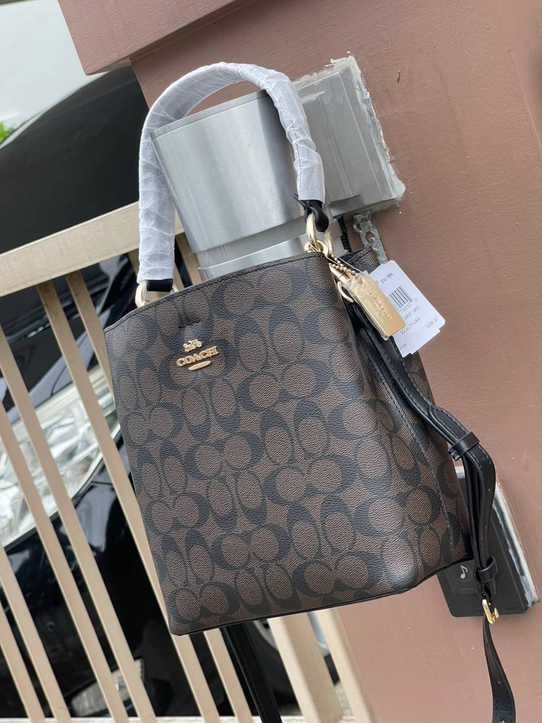 COACH SMALL TOWN BUCKET BAG IN SIGNATURE สำหรับสาวแฟชั่นที่ชอบรายละเอียดชิคๆ ดีไซน์สุดเก๋ แนะนำเลยสำหรับกระเป๋าทรงบักเก็ตใบนี้ เชื่อว่าสาว ๆ หลายคนชื่นชอบ เป็นไอเทมที่สามารถแมทช์ได้กับเสื้อหลากหลายสไตล์ บรรจุของได้เยอะโดยที่กระเป๋าไม่เสียทรง แบ่งช่องใช้งา