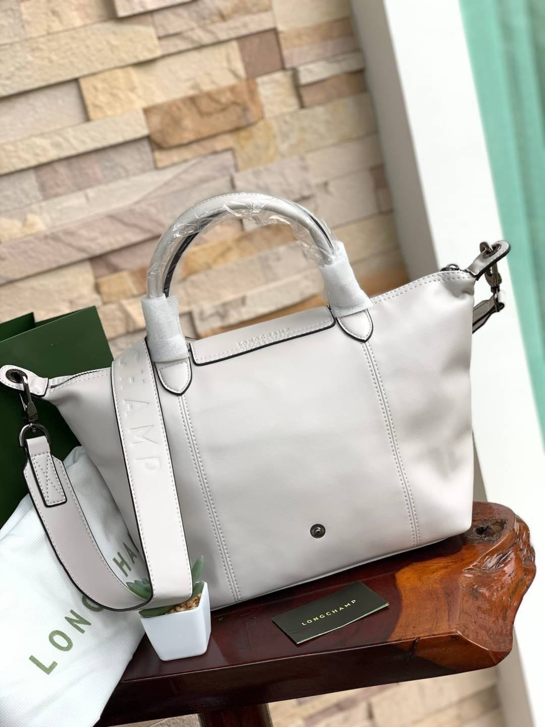 Longchamp LE PLIAGE CUIR TOP HANDLE BAG S เรียกว่าเป็นกระเป๋าอีกหนึ่งรุ่นที่ไม่ว่ายังไงก็ฮอตฮิตและติดเทรนด์ตลอดไม่เคยเปลี่ยนกับ ทรง Le Pliage Cuir หนึ่งในตระกูลกระเป๋าสุดไอคอนิกจากแบรนด์ เมื่อรุ่น Le Pliage Cuir ในรูปแบบของหนังแกะ Metis ได้ถือกำเนิดขึ้นใน