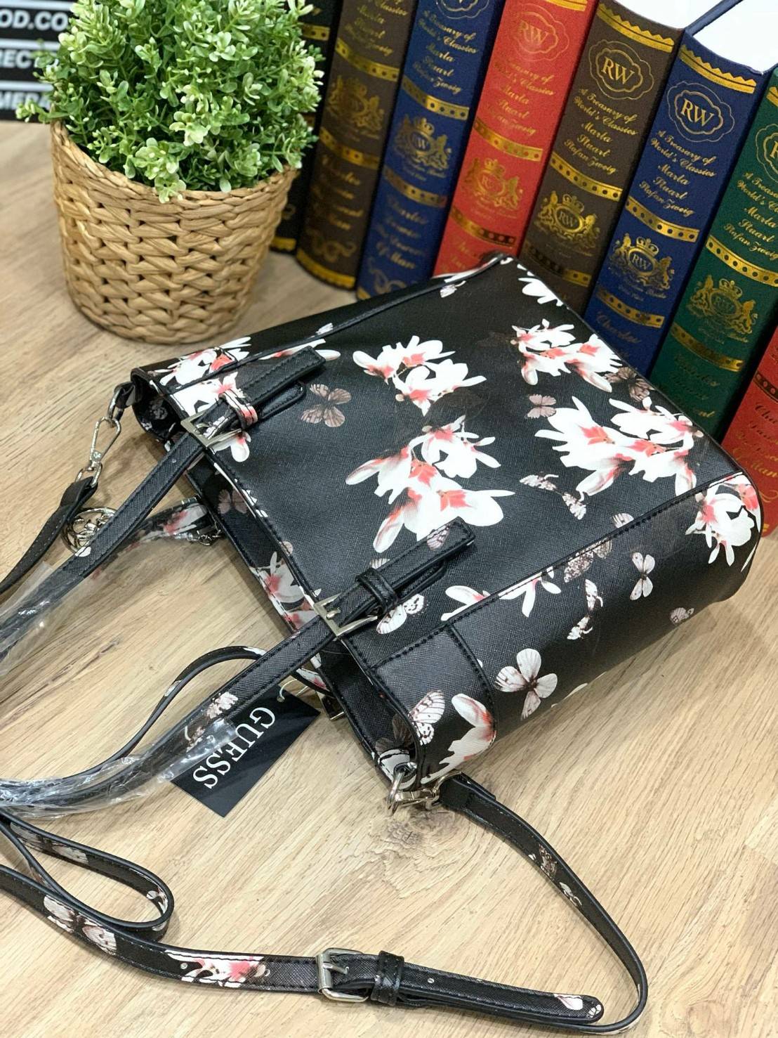 GUESS Women's Medium Floral Tote Bag กระเป๋าถือ คล้องไหล่หรือสะพาย ขนาดกลาง วัสดุหนังpu ลายดอกไม้ชนิดต่างๆรอบใบ เปิดปิดใช้งานด้วยซิปเดียวด้านบน ภายในมีกว้างใส่กระเป๋าสตาวค์ยาว มินิไอแพคได้ หูจับและสายสะพายปรับระดับได้ มาพร้อมกุญแจโลโก้guess สวยน่ารัก