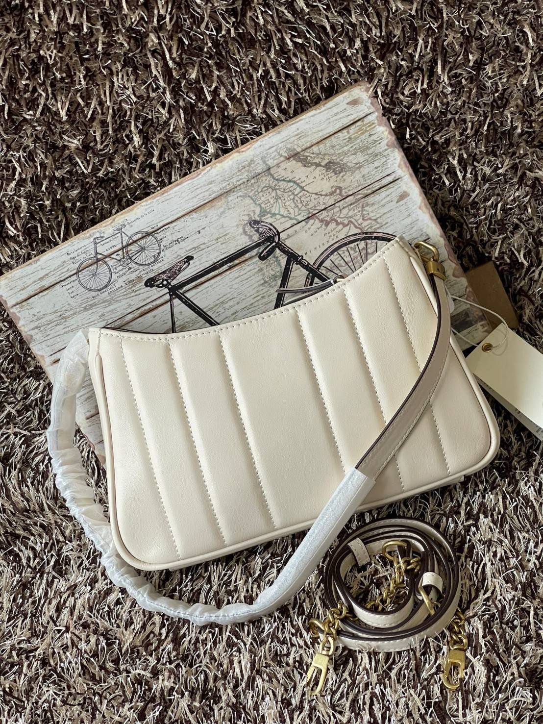 Tory burch Kira logo-plaque crossbody bag กระเป๋า Kira ของ Tory Burch เป็นส่วนหนึ่งของคอลเล็กชั่นที่โดดเด่น และมีหลายรุ่นด้วยกัน โดยมีป้ายโลโก้ Double T ของแบรนด์อยู่ตรงกลาง มีความเรียบง่ายแต่ยังคงความหรูหราโดดเด่นด้วยวัสดุบุผิว ป้ายโลโก้สีทอง สายสะพายโซ่