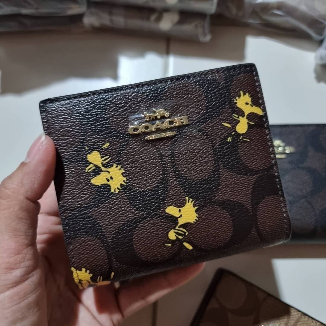 C4591 C4592 COACH COACH x PEANUTS SNAP WALLET IN SIGNATURE CANVAS WITH SNOOPY PRINT / WITH WOODSTOCK PRINT กระเป๋าสตางค์ใบเล็ก ขนาดกำลังเหมาะ ดีไซน์น่ารักอีกแล้วจ้า ♥️ มันน่ารักน่าใช้มาก โดดเด่นด้วยลายคอลเลคชั่นยอดฮิต วัสดุหนังแคนวาสเคลือบลาย เปิด-