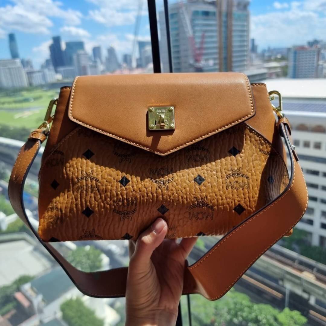 M.C.M ESSENTIAL CROSSBODY IN VISETOS กระเป๋าสะพายข้าง สวยอยู่ทรง ดีไซน์ไม่ซ้ำใคร มาพร้อมสายสะพายถึง 2 แบบ ปรับเปลี่ยนใช้ได้ไม่มีเบื่อ วัสดุหนังแคนวาสสลับหนังแท้ เปิด-ปิดกระเป๋าด้วยตัวบิดล็อคแน่นหนา ด้านหลังมีช่องเก็บบัตรได้ ภายในโล่งกว้าง แบ่งสัดส่วน เป็น
