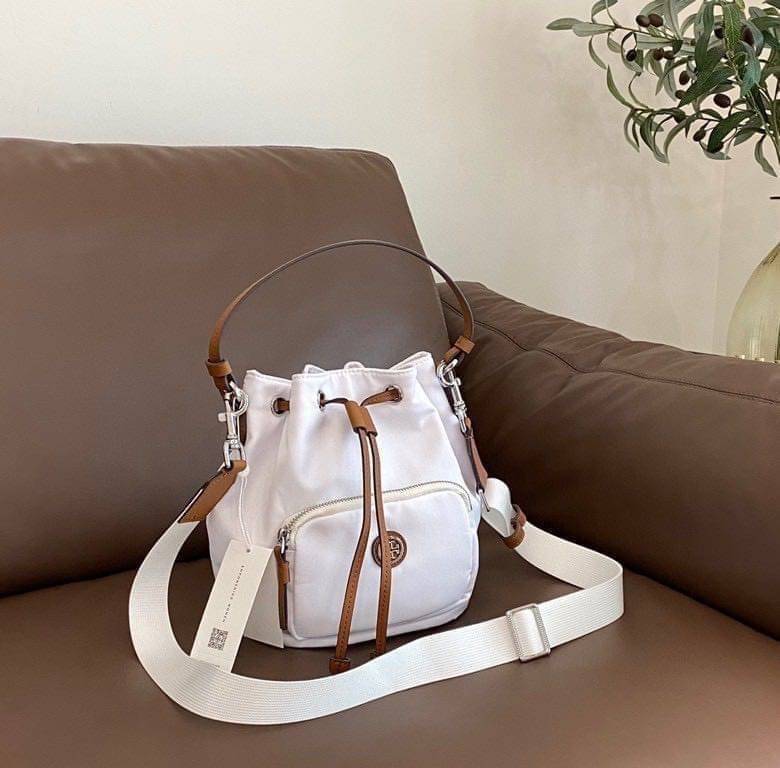 Tory Burch Virginia Nylon Bucket Bag / Tory Burch logo-plaque bucket bag กระเป๋าสะพายทรงบัคเก็ต เปิด-ปิดหนังรูดปากกระเป๋า มีหูหิ้วในตัว คล้องแขนเก๋ๆ ภายในเป็นช่องโล่ง มีช่องย่อย ใส่ของสำคัญจุกจิกได้ มีสายครอส จะสะพายไปไหนก็ได้ทุกโอกาส สวยเลิศทุกสี พร้อมส่