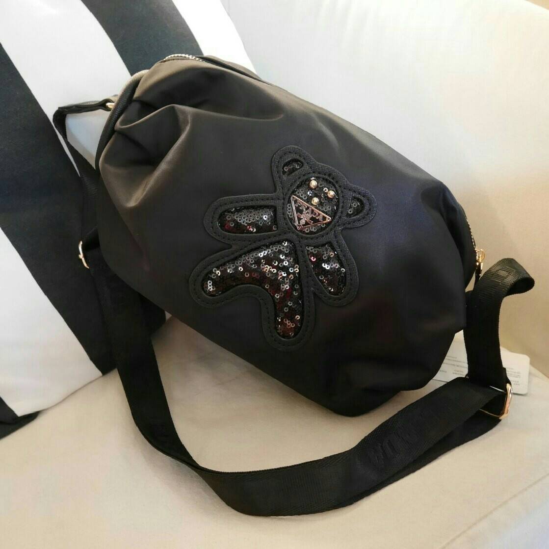 มาแล้วค้า! PRADA NYLON CROSSBODY BAG กระเป๋าสะพายพรีเมี่ยมกิ้ฟจากเคาน์เตอร์ต่างประเทศ Limited edition วัสดุ Nylon เนื้อหนาคุณภาพดีตามแบบฉบับแบรนด์ ขนาดใหญ่ จุได้เยอะ น้ำหนักเบา ด้านหน้าเป็นลายหมีปั๊กกลิ้ตเตอร์โลโก้แบรนด์อะไหล่ทองหรู ภายในซับ Polyester 100