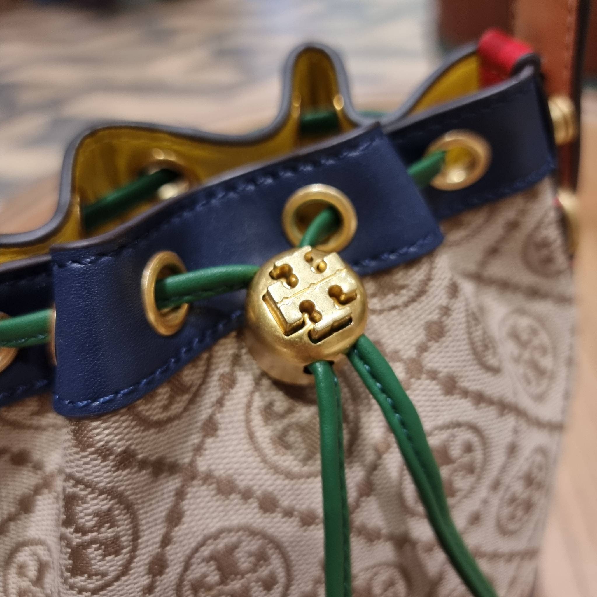MINI : TORY BURCH T MONOGRAM COLOR-BLOCK JACQUARD MINI BUCKET BAG ใหม่ล่าสุด กับกระเป๋าบัคเก็ตทรงสวย ไซส์มินิ ในราคาน่ารัก โดดเด่นด้วยลวดลายเอกลักษณ์ ผสานลายคัลเลอร์บล็อค โทนสีตัดกันอย่างลงตัว ถักทอบนวัสดุ woven jacquard ลายคมชัด สลับส่วนของหนังแท้ ภายในเ