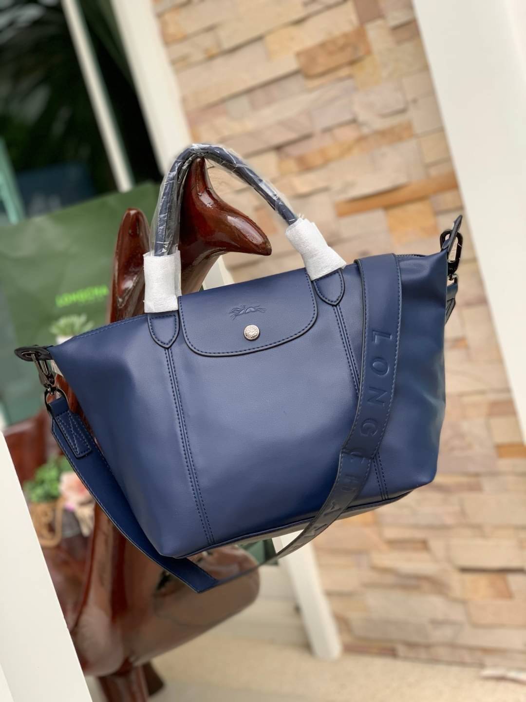 Longchamp LE PLIAGE CUIR TOP HANDLE BAG S เรียกว่าเป็นกระเป๋าอีกหนึ่งรุ่นที่ไม่ว่ายังไงก็ฮอตฮิตและติดเทรนด์ตลอดไม่เคยเปลี่ยนกับ ทรง Le Pliage Cuir หนึ่งในตระกูลกระเป๋าสุดไอคอนิกจากแบรนด์ เมื่อรุ่น Le Pliage Cuir ในรูปแบบของหนังแกะ Metis ได้ถือกำเนิดขึ้นใน