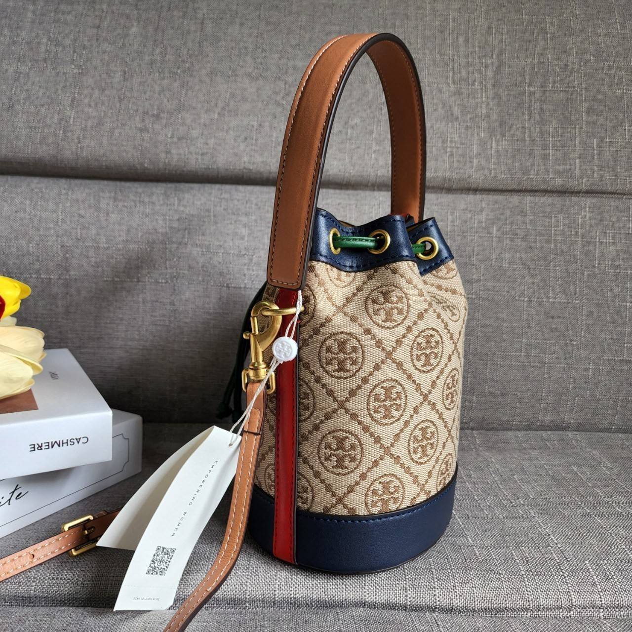 TORY BURCH T MONOGRAM COLORBlOCK JACQUARD MINI BUCKET BAG คอลเลคชั่นใหม่ล่าสุด ครอบครองก่อนใคร รุ่นบัคเก็ตทรงจีบ วัสดุ jacquard สลับหนังแท้ ตัดขอบข้างสีแดงทำให้ดูโดดเด่น หูจับหนังแท้ เปิด ปิด แบบหูรูด ภายในช่องโล่งกว้าง มาพร้อมสายสะพายข้างหนังแท้ ปรับระดั