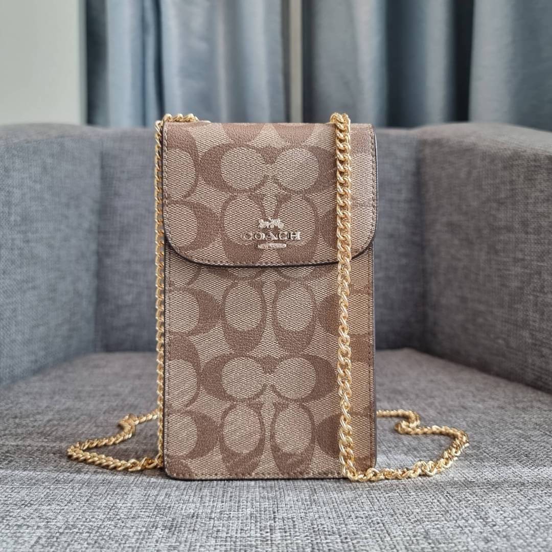 COACH NORTH/SOUTH PHONE CROSSBODY IN SIGNATURE CANVAS F55636 F39955 สุดคลาสสิคกับกระเป๋าสะพายเอนกประสงค์ Case phone ใส่โทรศัพท์มือถือได้ทุกรุ่น ดีไซน์ลายเอกลักษณ์ วัสดุหนังแคนวาสเคลือบลาย ฝาและภายในเป็นหนังสังเคราะห์เรียบ เปิด-ปิดด้วยกระดุม สายสะพายยาวประ