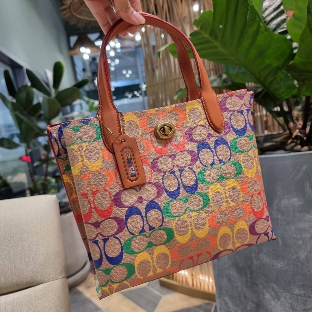 COACH CA102 WILLOW TOTE 24 IN RAINBOW SIGNATURE CANVAS ไปให้สุดกับความเลิศของลวดลายสายรุ้ง ที่แต่งแต้มลงบนกระเป๋าทรงโท้ท ไซส์กำลังสวย พกพาได้สะดวก มีตัวบิดล็อคที่ปากกระเป๋าด้านหนึ่ง และกระดุมแม่เหล็กอีกด้านหนึ่ง ภายในโล่งกว้าง เก็บของได้เป็นสัดส่วนไปเลย ม