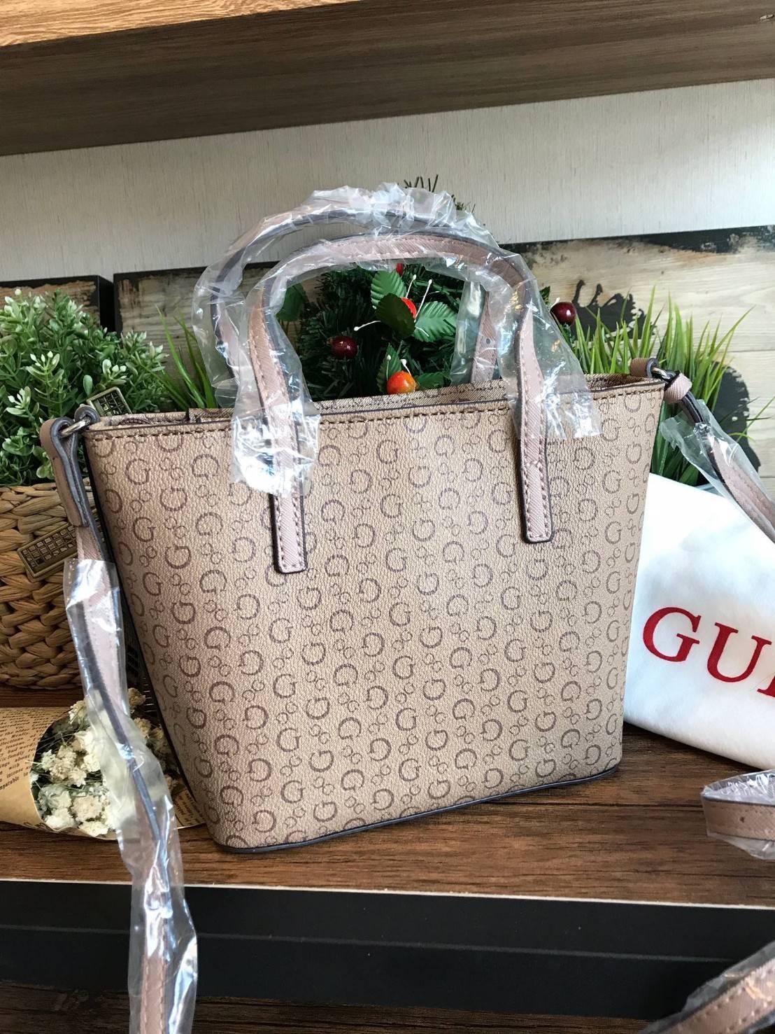 GUESS Factory Women's Diem Logo-Print Mini Tote Bag กระเป๋าถือหรือสะพาย วัสดุpolyesterกันน้ำได้ มีลายsignatureลาย G รอบใบ เปิดปิดด้วยซิปเดียวด้านบน ภายในบุผ้าลายsignatureเช่นเดียวกับด้านนอก สายและหูจับปรับระดับได้ ใช้งานได้หลายโอกาสคร้า!!