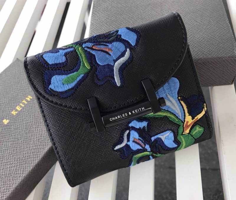 BEST SELLER! CHARLES & KEITH Peforated Wallet กระเป๋าสตางค์ใบสั้นพับ3ตอนรุ่นยอดนิยมวัสดุหนัง Saffiano สีดำประดับลายดอกไม้ Van Goh คลาสสิค ดีไซน์สวยเก๋ไม่ซ้ำใคร ด้านหน้าปั้มโลโก้เปิดปิดด้วยกระดุมเเม่เหล็ก ภายในมีช่องซิปสำหรับใส่เหรียญ หัวซิปปั้มโลโก้ มีช่อ