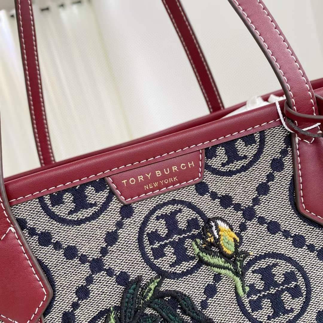Tory Perry Embroidered T Monogram Triple Compartment Tote Bag เป็นแพทเทิร์นที่ได้รับแรงบันดาลใจจากการควิลท์สไตล์เพนซิลเวเนียดัตซ์ดั้งเดิมและเฉลิมฉลองโลโก้อันเป็นสัญลักษณ์ของแบรนด์ วัสดุผ้าแจ็คการ์ดแบบทอหนัง อะไหล่ทอง โดดเด่นด้วยลายเสือชีร์ต้าร์ งานเย็บปัก