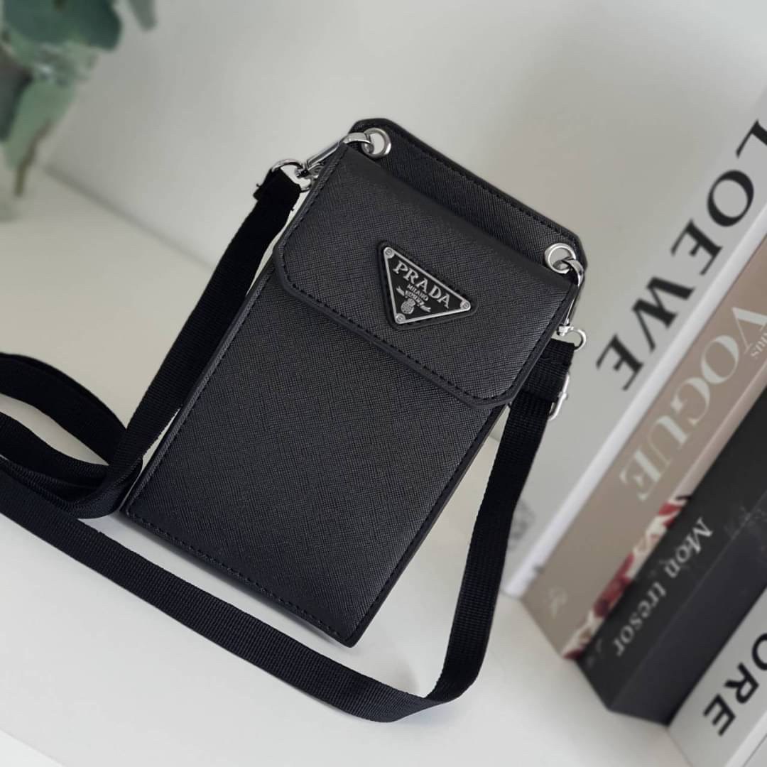 PRADA PHONE CASE ไอเท็มสุดคลาสสิคที่ทุกท่านควรมี! Prada Saffiano Leather Smartphone Case งานพรีเมี่ยมกิ้ฟท์จากเคาเตอร์ต่างประเทศ ของมีจำนวนจำกัด หนังลาย saffiano อยู่ทรงสวย ดีไซน์หรูหรา ดูดี ทรงCrossbody ด้านหน้ามีโลโก้แบรนด์ อะไหล่ทอง ด้านในเปิดปิดด้วยกร