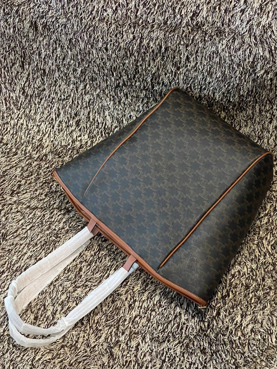 Celine Medium shopping bag in Triomphe canvas มาในรูปแบบ กระเป๋า Shopping Bag ใบสวยสง่า เป็นกระเป๋าดีไซน์เรียบง่าย แมตช์ได้กับทุกชุด ผลิตจากผ้าแคนวาสชนิดพิเศษซึ่งโดดเด่นด้วยลายเอกลักษณ์ของ Triompe เป็นใบที่เหมาะกับการใช้ประจำวันเป็นอย่างมาก ด้วยรูปทรงสี่เ