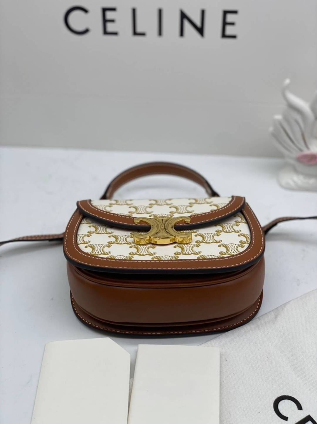 CELINE Mini besace triomphe in shiny top handle กระเป๋าสะพายคาดลำตัวพร้อมหูจับถนัดมือ ได้รับความนิยมอย่างมาก ด้วยรูปร่างทรงโค้งมนมีความคลาสสิกตามแบบฉบับแบรนด์