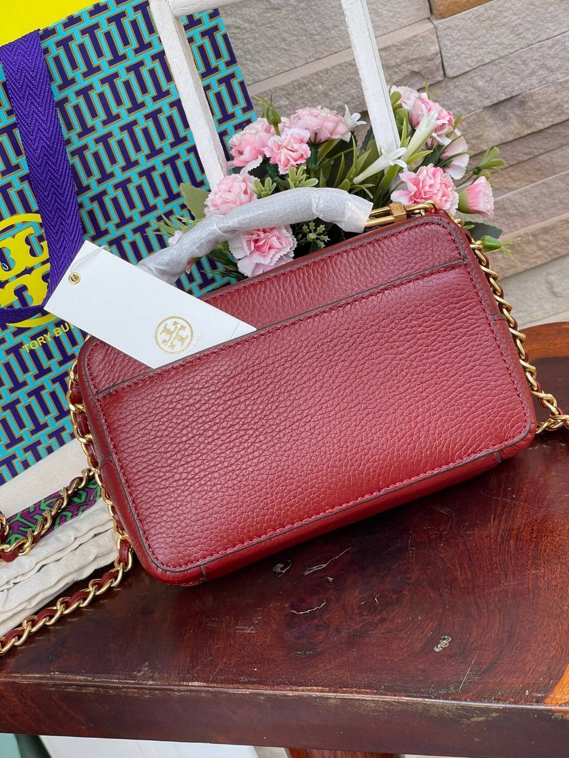 Tory burch Top Handle Case (84710) Collection ใหม่ที่เพิ่งเปิดตัวไปไม่นานจุดเด่นของรุ่นนี้คือดีไซน์ออกมาในสไตล์คลาสสิกที่มาพร้อมกับฮาร์ดแวร์ที่ทำจากวัสดุทองเหลืองและสายสะพายโซ่และหนัง ปากกระเป๋าเปิดได้กว้างแบบสองซิป รูปทรงสามารถสะพายใช้งานได้หลายโอกาส ไม่