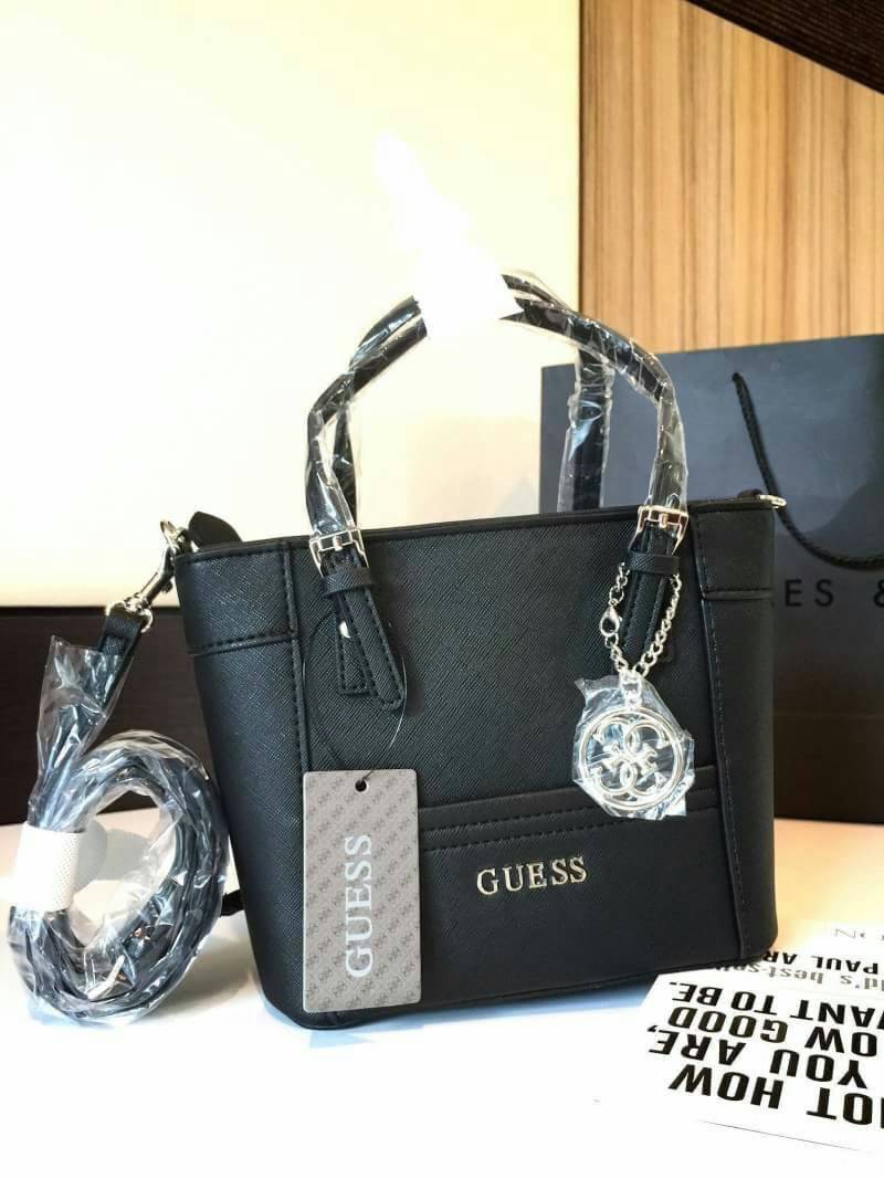 GUESS SAFFIANO MINI CROSS BODY BAG Best aellwr กระเป๋าถือหรือสะพายรุ่นยอดนิยมจาก GUESS หนัง Saffiano สวยอยู่ทรงสไตล์ PRADA ขนาดกำลังดี เบา ด้านหน้าประดับ logo brand มาพร้อมพวงกุญแจแบรนด์ห้อยที่หูกระเป๋า ถอดเเยกใช้ได้ เปิดปิดด้วยซิปสะดวกใช้ ภายในมี โลโก้ ช