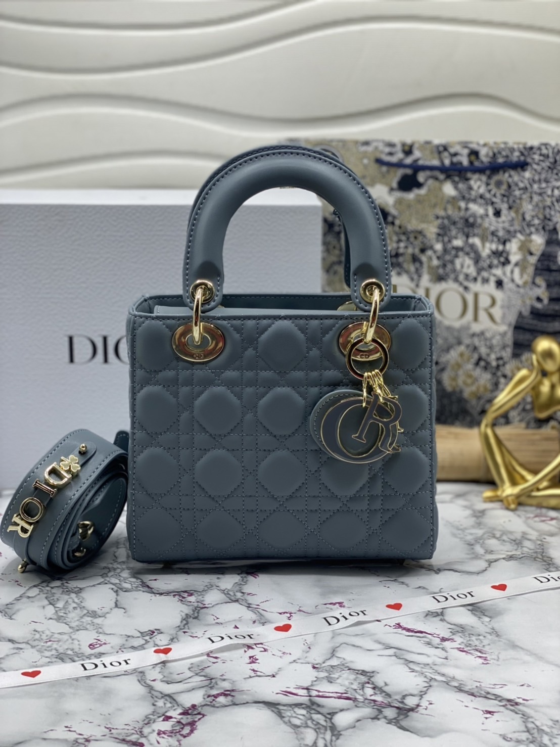 หนังแท้ DIOR LADY BAG 20cm ความสง่างามอีกหนึ่งรุ่นของ Dior รูปทรงสีเหลียม ขนาดกระทัดรัด ตั้งอยู่ทรง ฐานกระเป๋าแข็งแรง มีหมุดรองฐาน ดีไซน์ที่มีเอกลักษณ์เฉพาะตัว ด้านหน้าตกแต่งด้วยตัวอักษร D.I.R ห้อยเป็นพวงกุญแจ จะถือด้วยมือหรือสะพายไหล่ก็ดูดีมากๆ ค่ะ