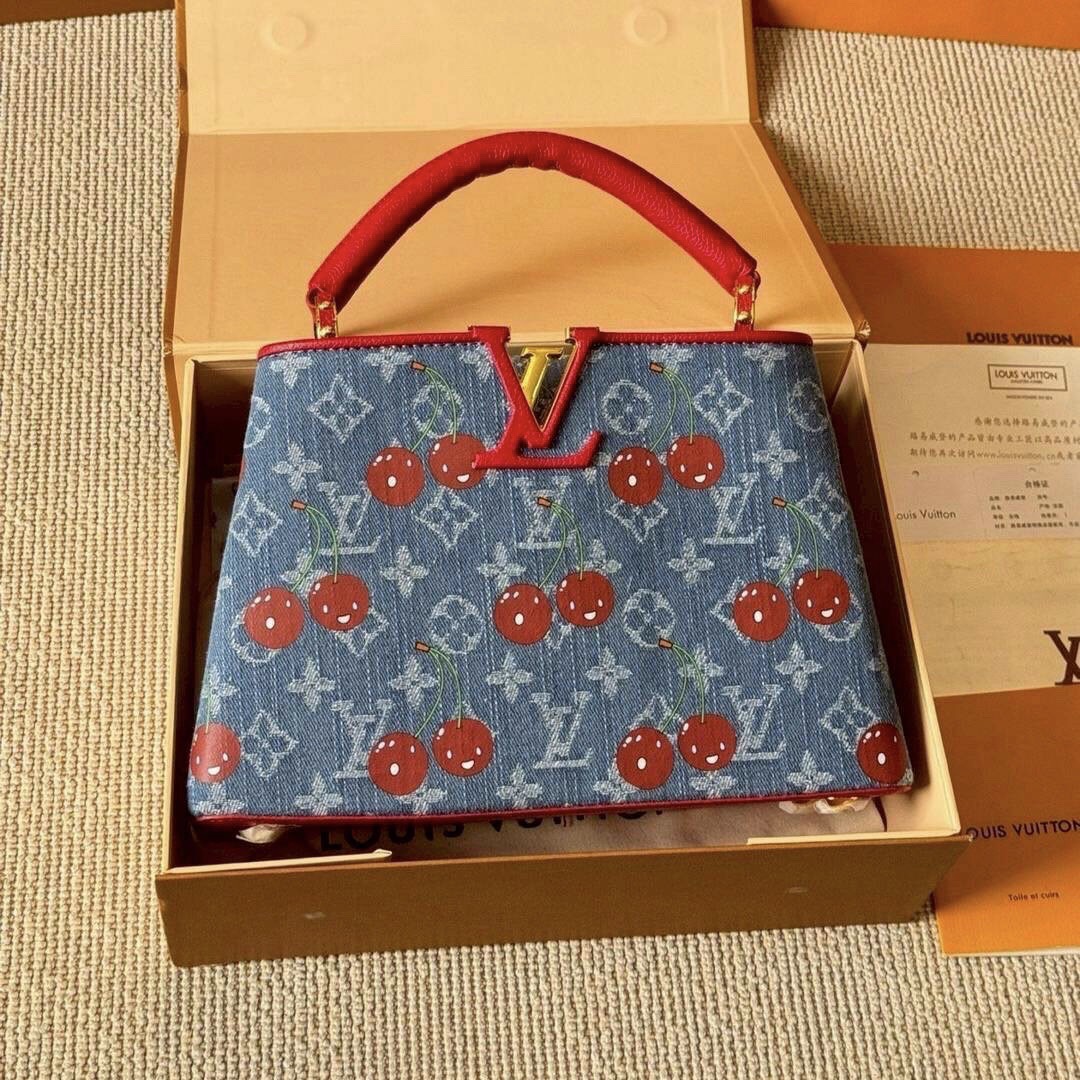 LV Capucines Monogram cherry denim กระเป๋าถือสุดหรูรูปทรงสวยคลาสสิกมาพร้อมหูจับในตัว สวยคมสะกดทุกสายตา ที่สุดของความสวยในราคาเบาๆ โดดเด่นมีชีวิตชีวา ด้วยเดนิมวินเทจปักลายเชอร์รี่สีสันสดใสสะดุดตาสะท้อนสไตล์ไอคอนิก