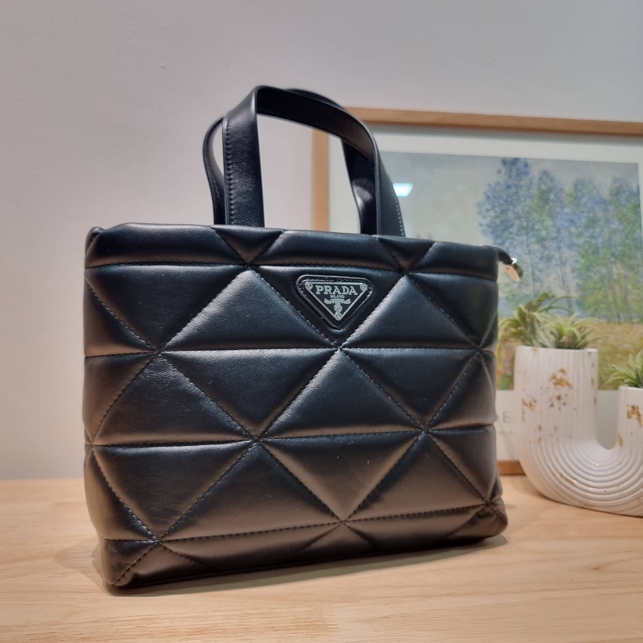 PRADA LEATHER PADDED BAG ใหม่ล่าสุด กับคอลเลคชั่นที่ทำออกมาตอบโจทย์ได้ทุกไลฟ์สไตล์ และเป็นยูนิเซ็กส์ กับกระเป๋าทรงโท้ท ขนาดกำลังดี