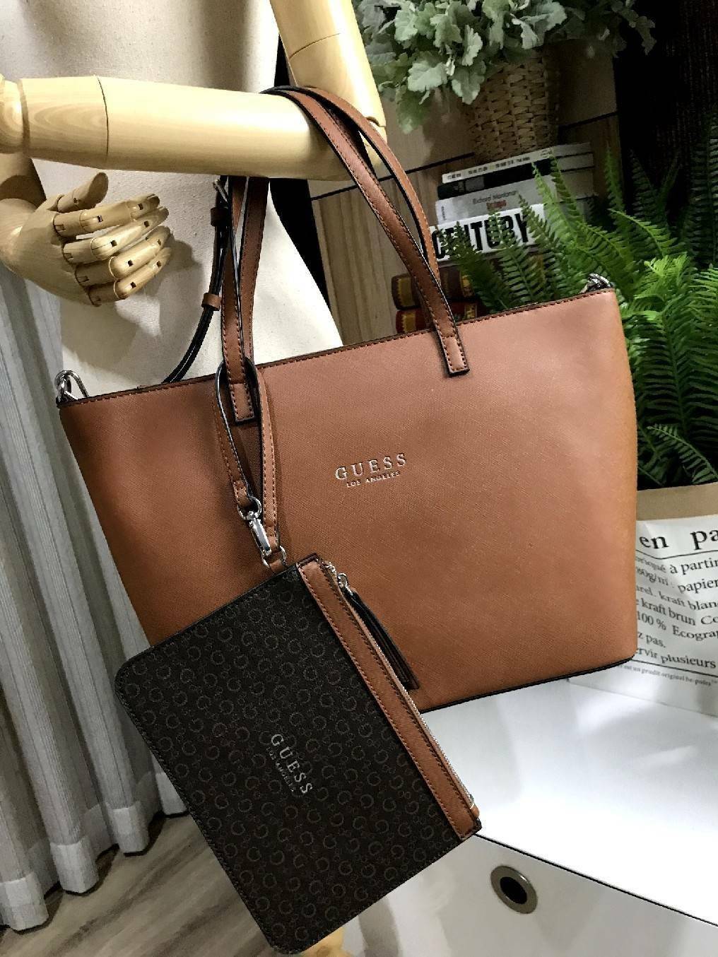 GUESS LARGE SHOPPER BAG WITH POUCH กระเป๋าสะพายรุ่นใหม่ล่าสุดจาก GUESS FACTORY หนัง Saffiano สวยหรูอยู่ทรง ด้านหน้ามีโลโก้แบรนด์ ด้านหลังมีช่องใส่ของ หูหิ้วสะพายไหล่ได้มาพร้อมสายสะพายยาวถอดได้ปรับได้ มีกระเป๋าใบเล็กเข้าชุดกันห้อยที่หูหิ้ว ใบเล็กถอดเเยกใช้