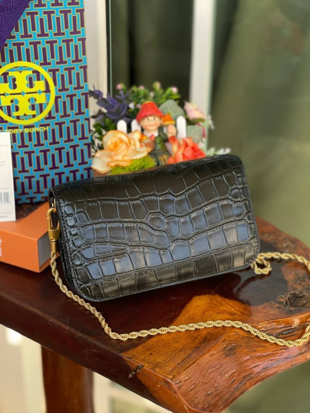 Tory Burch Eleanor Crocodile-Embossed Phone Crossbody Bag จุดเด่นของรุ่นนี้คือดีไซน์ออกมาในสไตล์คลาสสิกที่มาพร้อมกับฮาร์ดแวร์ที่ทำจากวัสดุทองเหลืองและสายสะพายโซ่เกลียวสีทอง ซึ่งการออกแบบได้รับแรงบันดาลใจมาจากเครื่องประดับ รูปทรงกะทัดรัดจึงสามารถสะพายใช้งา